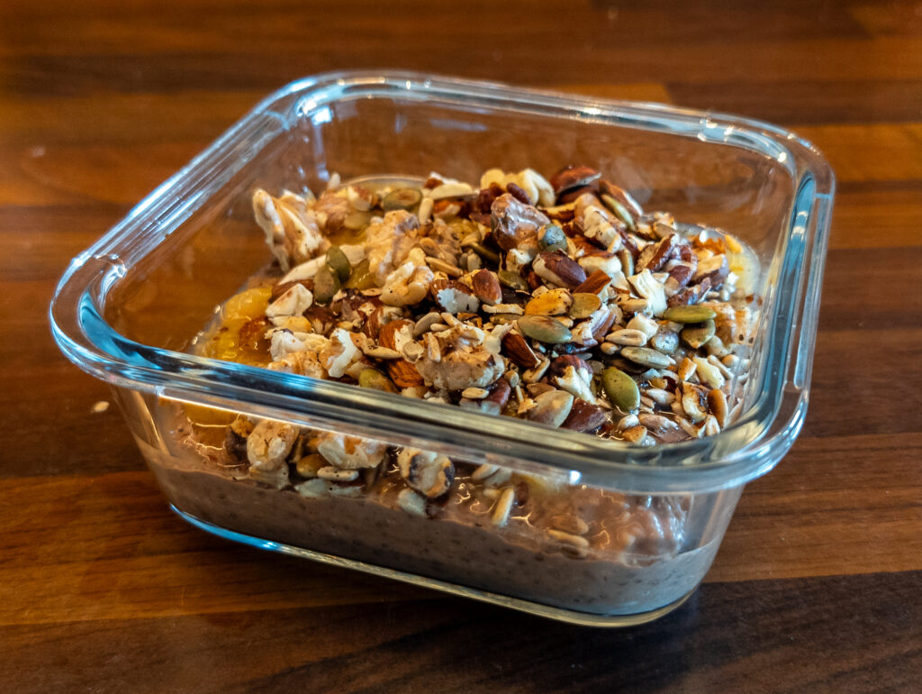 Kjøleskapsgrøt med sjokolade og kokos, toppet med nøtter og frø.